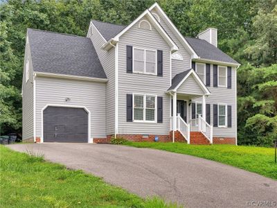 View of front facade with a garage and a front yard | Image 3