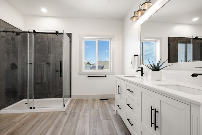 Bathroom featuring wood finished floors, double vanity, a shower stall, and recessed lighting | Image 34