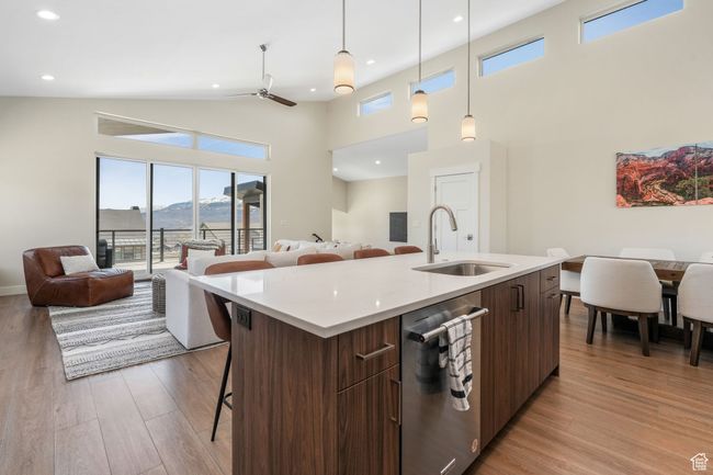 A spacious open concept living room, seamlessly connecting to the kitchen and dining areas, which lead out to a serene balcony. | Image 31