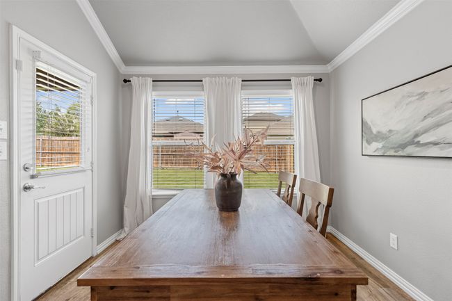 Dining room featuring wood like tile floors, ornamental molding, and lofted ceiling | Image 21