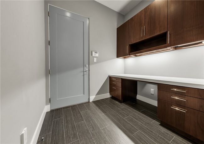 Unfurnished office with built in study area and wood tiled floors | Image 19