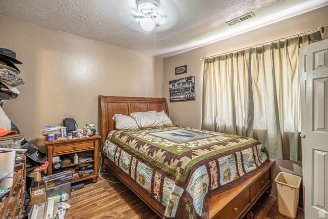 Bedroom featuring wood finished floors and a textured ceiling | Image 41