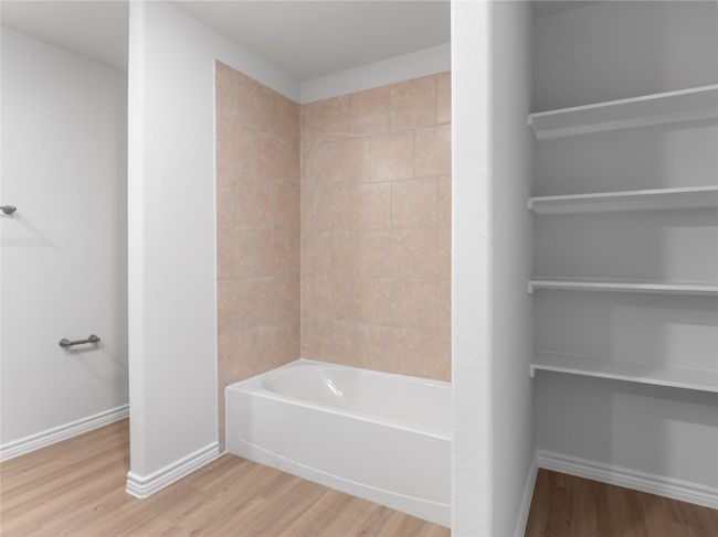 Upstairs master bath featuring built-in shelves and a separate tub for ultimate relaxation. | Image 19