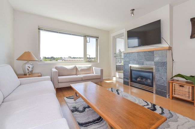 Living area with a fireplace and wood finished floors | Image 4