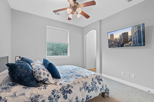 Carpeted bedroom featuring baseboards, a ceiling fan, and arched walkways | Image 17