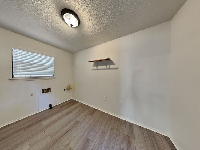 Unfurnished room featuring wood finished floors, a textured ceiling, and baseboards | Image 15