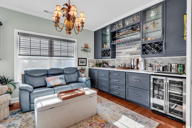 Staircase featuring crown molding, indoor bar, wood-type flooring, and beverage cooler | Image 4