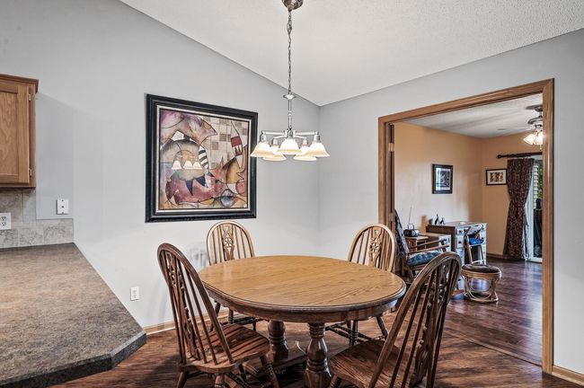 The dining area can easily accommodate larger gatherings while the kitchen peninsula offers additional casual seating. | Image 7