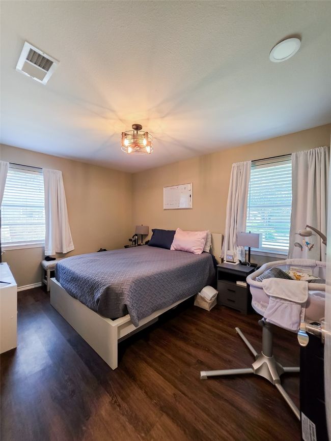Bedroom featuring wood finished floors, multiple windows, and a chandelier | Image 11