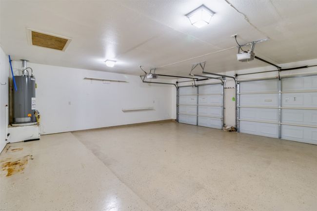 Garage featuring a garage door opener and water heater | Image 32