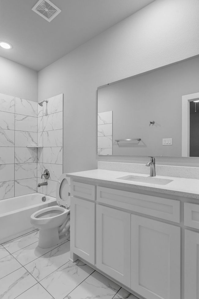 Bathroom featuring marble finish floor, shower / bath combination, visible vents, and vanity | Image 17