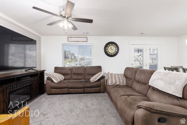 Living area featuring visible vents, light colored carpet, and a ceiling fan | Image 10
