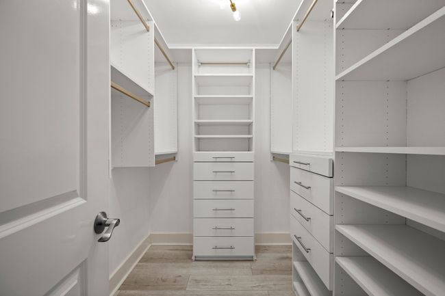 Walk in closet featuring light wood-style floors | Image 13
