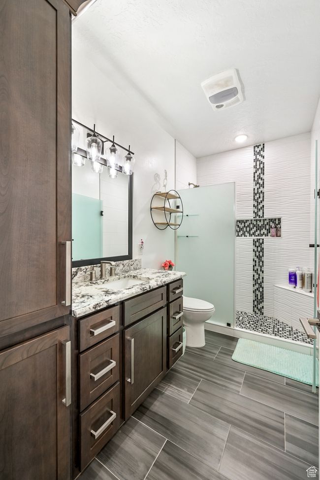 Bathroom featuring vanity and tiled shower | Image 75
