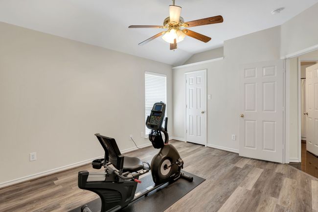Exercise or Bedroom area featuring ceiling fan, lofted ceiling, Luxury Vinyl floors with walk-in closet | Image 27