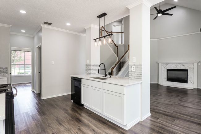 Kitchen featuring a sink, dishwasher, ceiling fan, range, and dark wood-style floors | Image 9