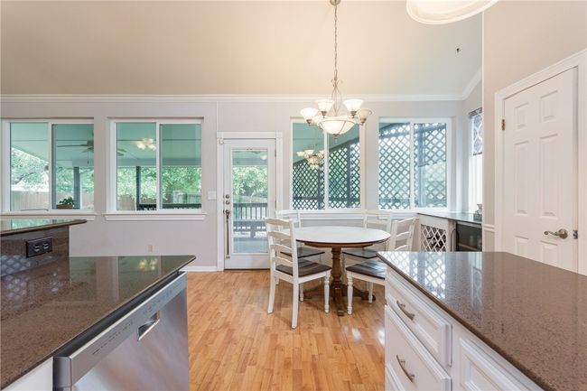 Dining area with a chandelier, light wood finished floors, ornamental molding, and lofted ceiling | Image 8