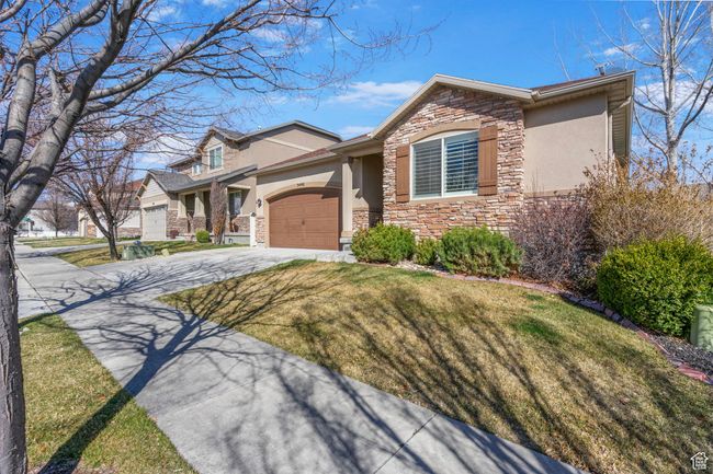 View of front of property with stone siding, concrete driveway, stucco siding, and an attached garage | Image 38