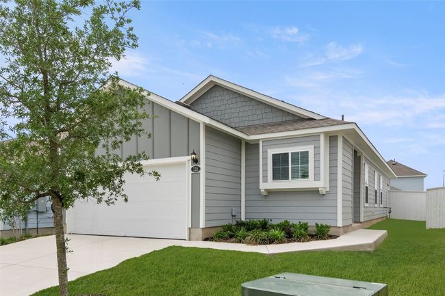 View of front of property with board and batten siding, fence, a garage, concrete driveway, and a front yard | Image 17
