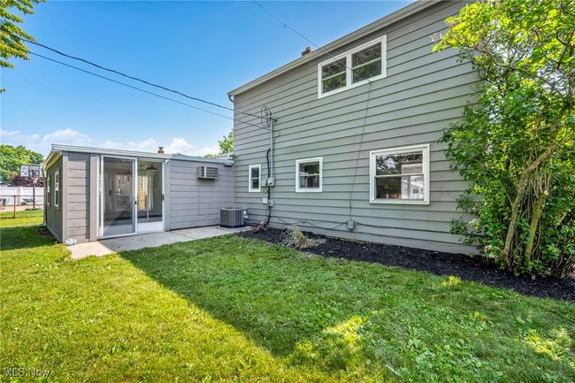 Back of house featuring a lawn and an AC wall unit | Image 45