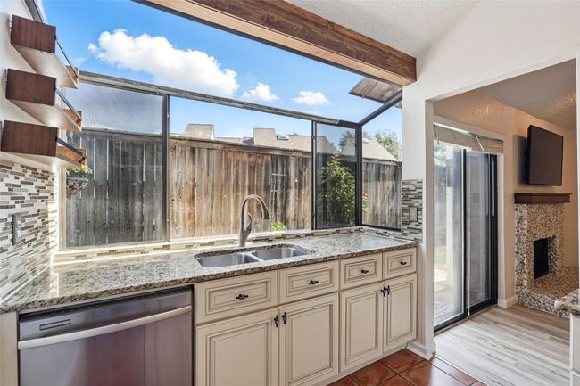 Kitchen with dishwasher, cabinets, a sink, backsplash, and granite counters | Image 4