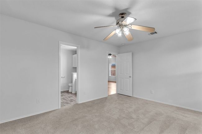 Unfurnished bedroom with carpet, ensuite bath, and ceiling fan | Image 18