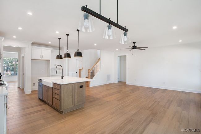 Photo represents the plan, not the actual home. Design selections may vary. A spacious kitchen with an island and pantry open to an adjoining dining area and the family room. | Image 14
