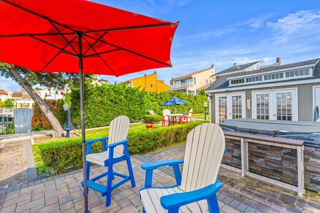 View of patio featuring french doors, an outbuilding, a storage structure, and a residential view | Image 31