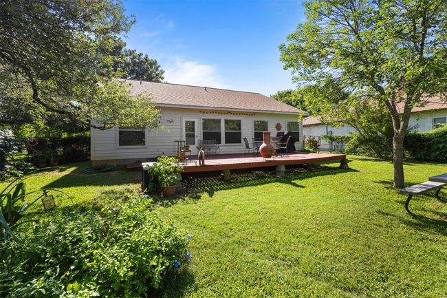 Rear view of house with a deck, a lawn, and a shingled roof | Image 27
