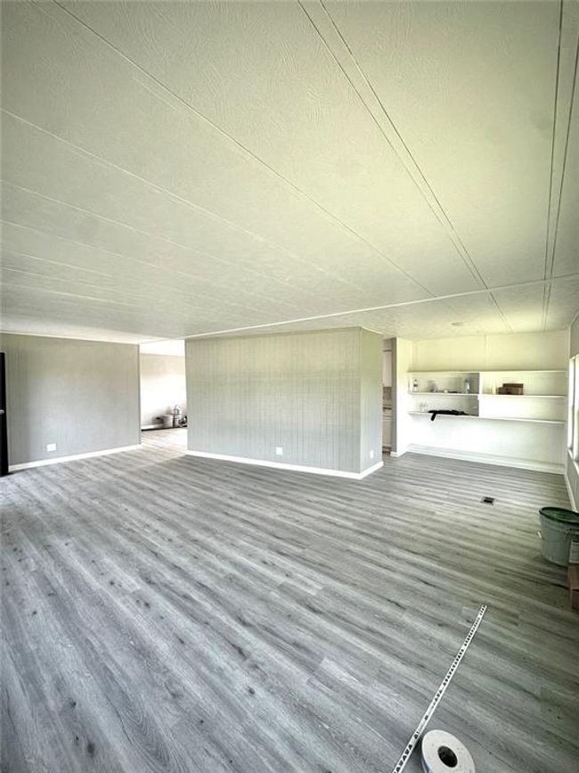 Unfurnished living room with wood finished floors and baseboards | Image 12