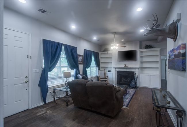 Living area featuring wood finished floors, recessed lighting, ceiling fan, and a fireplace | Image 6