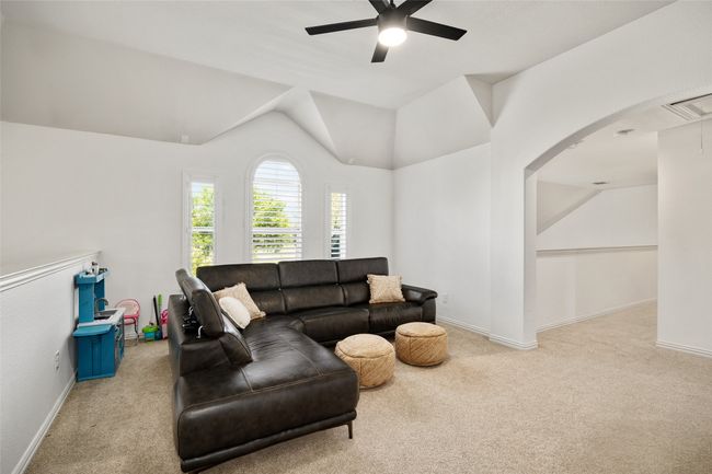 Living area featuring ceiling fan, carpet, visible vents, vaulted ceiling, and baseboards | Image 25