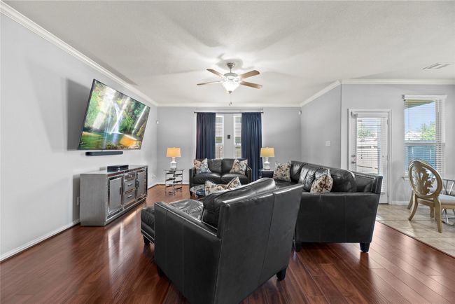 Several windows in the living room fill the space with natural light while offering a clear view of the backyard. This creates a bright and open atmosphere, perfect for everyday living and entertaining. | Image 9