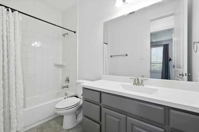 Bathroom featuring shower / bath combination with curtain, vanity, and tile patterned flooring | Image 15