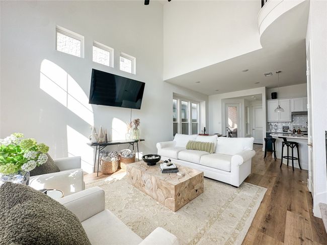 Living area with a high ceiling and wood finished floors | Image 5