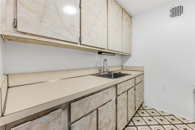 Kitchen featuring light brown cabinetry, visible vents, light countertops, and a sink | Image 6