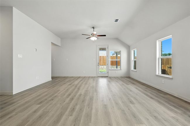 Unfurnished living room with a ceiling fan, light wood-style flooring, and lofted ceiling | Image 10