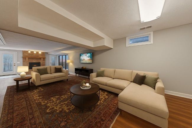 Spacious lower-level family room featuring a cozy fireplace, walkout access, and stylishly staged seating perfect for entertaining or relaxing.(virtually staged) | Image 26