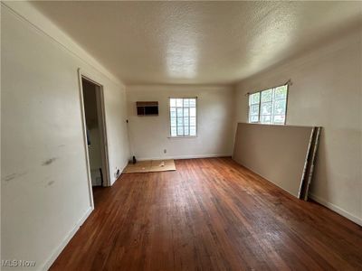 Spare room featuring dark hardwood / wood-style floors and a textured ceiling | Image 2