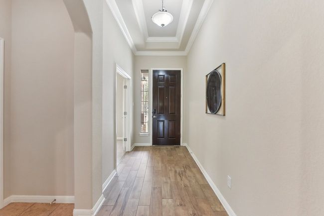 Look up at the beautiful tray ceiling that greets you as you enter this home - | Image 7