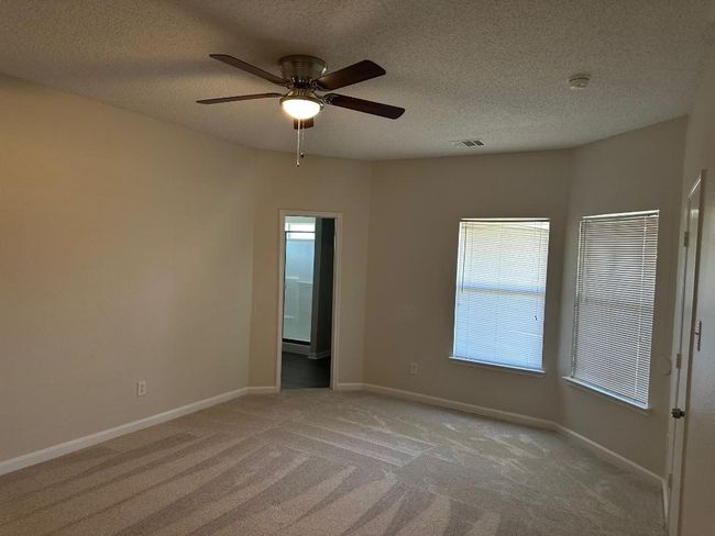 Spare room featuring light carpet, ceiling fan, baseboards, a smoke detector, and a textured ceiling | Image 10