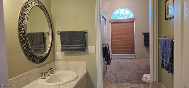 Full bathroom featuring tile walls, toilet, tile patterned flooring, and vanity | Image 8