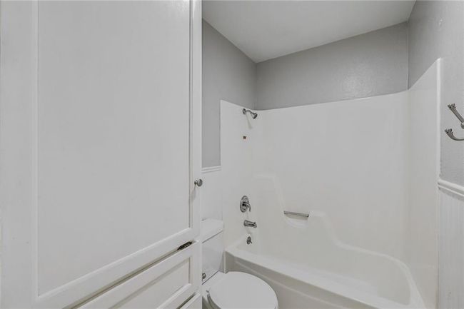 Bathroom featuring toilet and shower / tub combination | Image 13