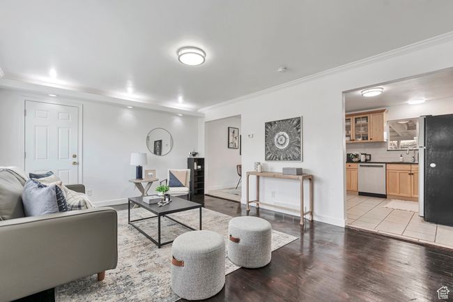 Living room with light wood-type flooring, baseboards, and ornamental molding | Image 8