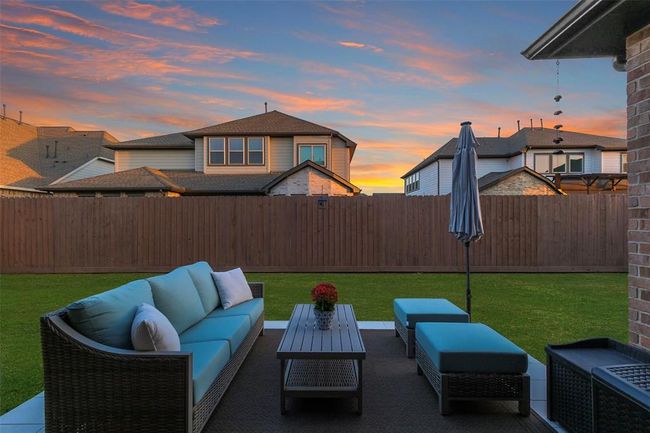 The back yard features an extended patio, a large covered patio area and recent fence. | Image 10