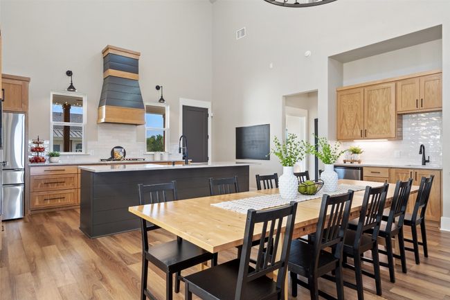 Dining room featuring a towering ceiling and light wood-style flooring | Image 8