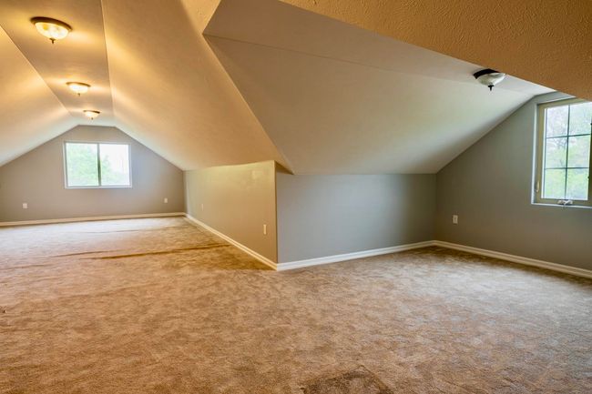 Additional living space with carpet flooring, baseboards, and vaulted ceiling | Image 27