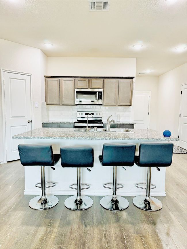 Kitchen with appliances with stainless steel finishes, light wood-style flooring, tasteful backsplash, and recessed lighting | Image 8