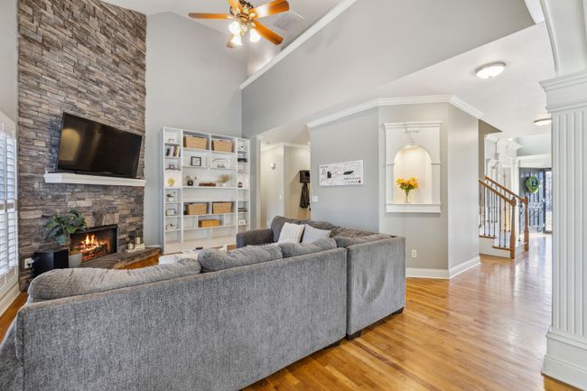 The main living room is two story with a second story overlook into the downstairs. Straight ahead is access to the garage, primary suite and the conveniently located half bath. | Image 21