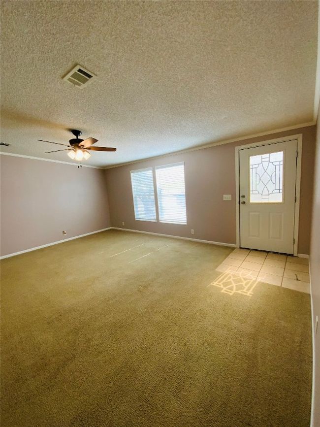 Foyer with a textured ceiling, visible vents, baseboards, and light carpet | Image 9
